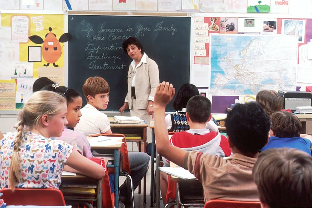 A teacher at the front of an elementary classroom