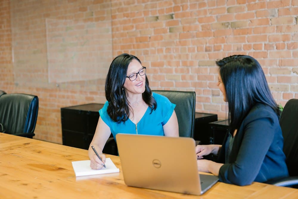 Two people talking across a table in an interview